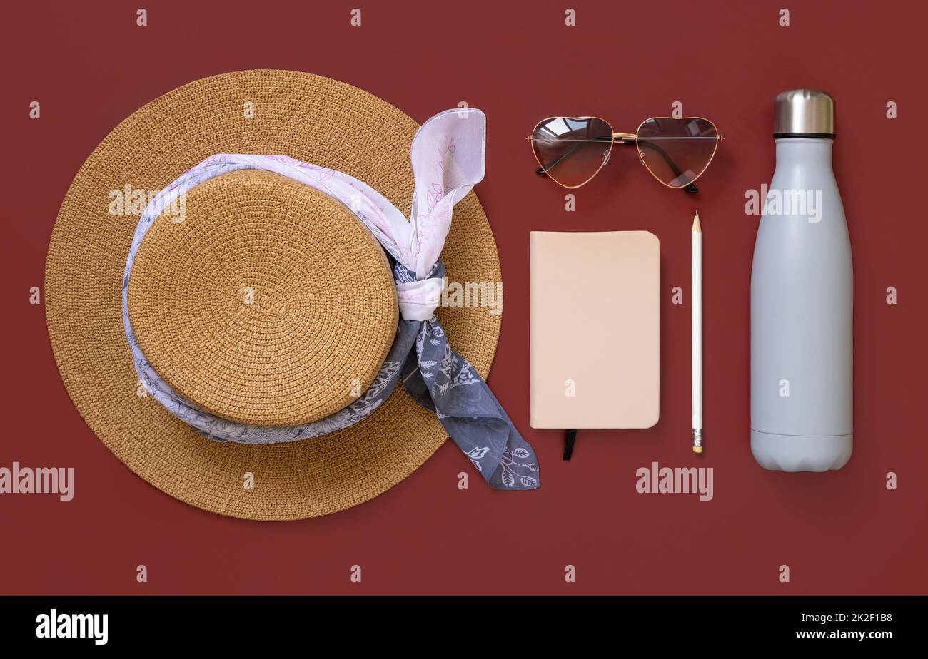 Female summer clothes and accessories flat lay. Hardcover textbook and bottle mockup. Stock Photo
