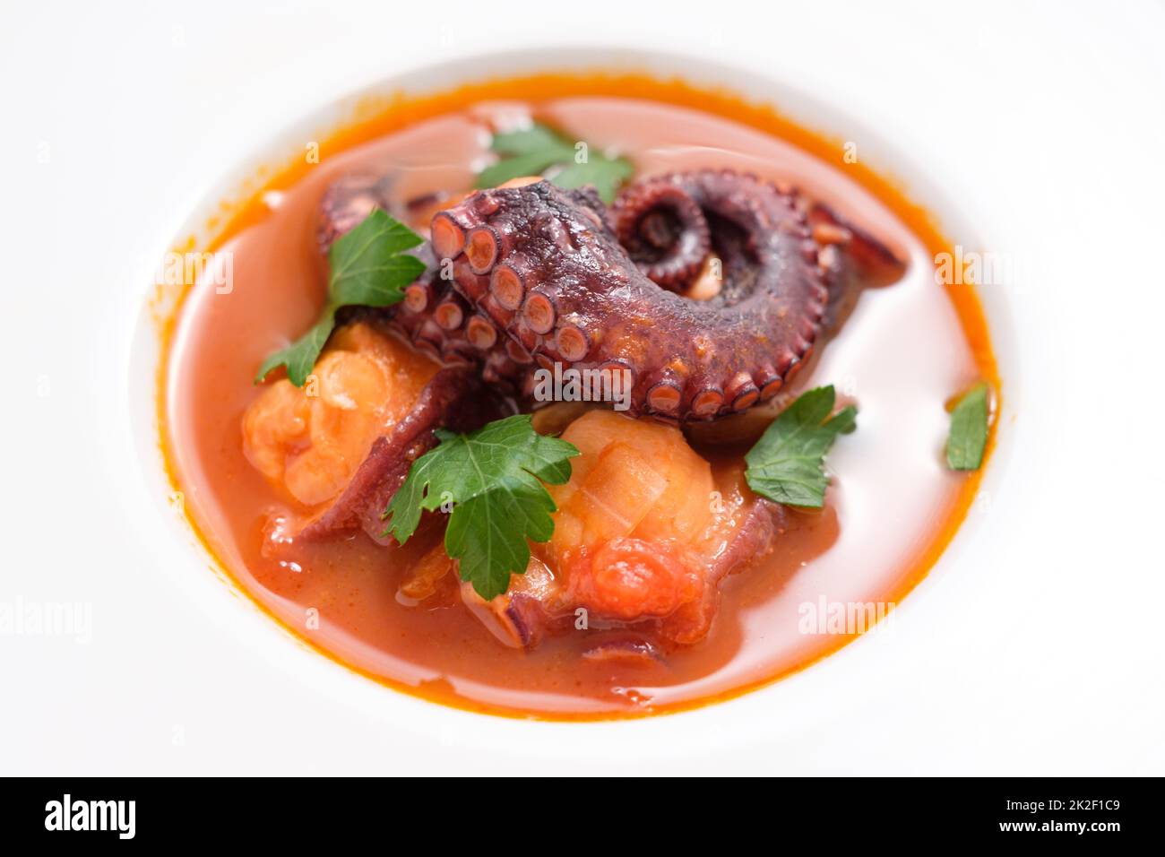 Octopus arm in tomato sauce with parsley from above Stock Photo