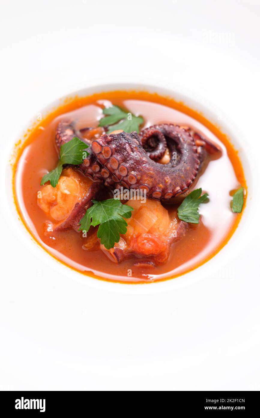 Stewed octopus and tomato with parsley in a restaurant Stock Photo
