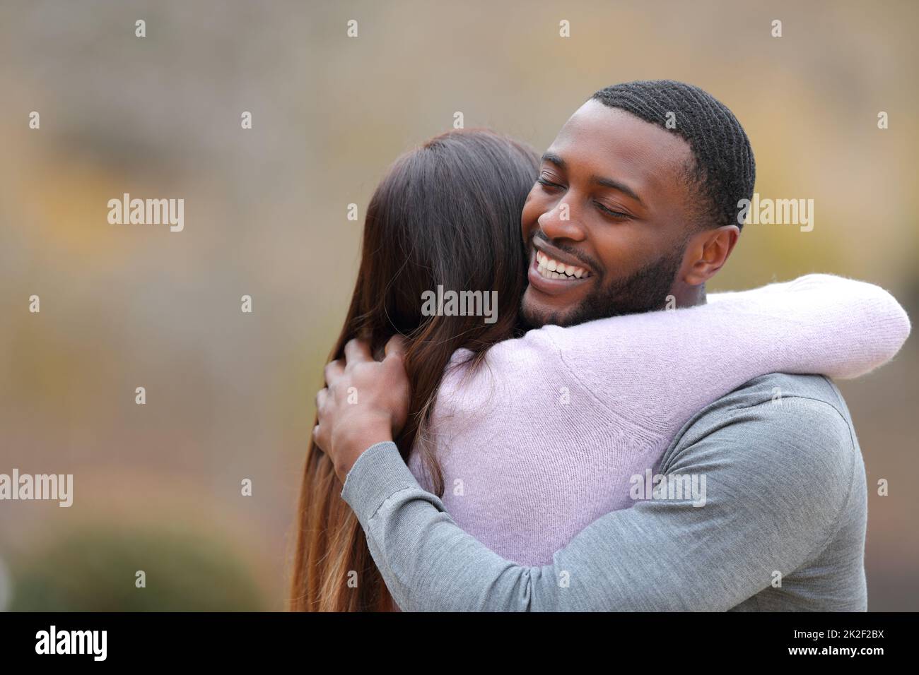 Couple hugging and happy man smiling in a park Stock Photo