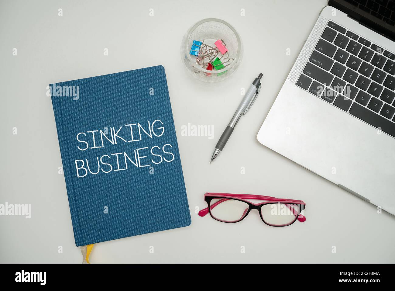 Handwriting text Sinking Business. Business showcase the company or other organization that is failing Office Supplies Over Desk With Keyboard And Glasses And Coffee Cup For Working Stock Photo