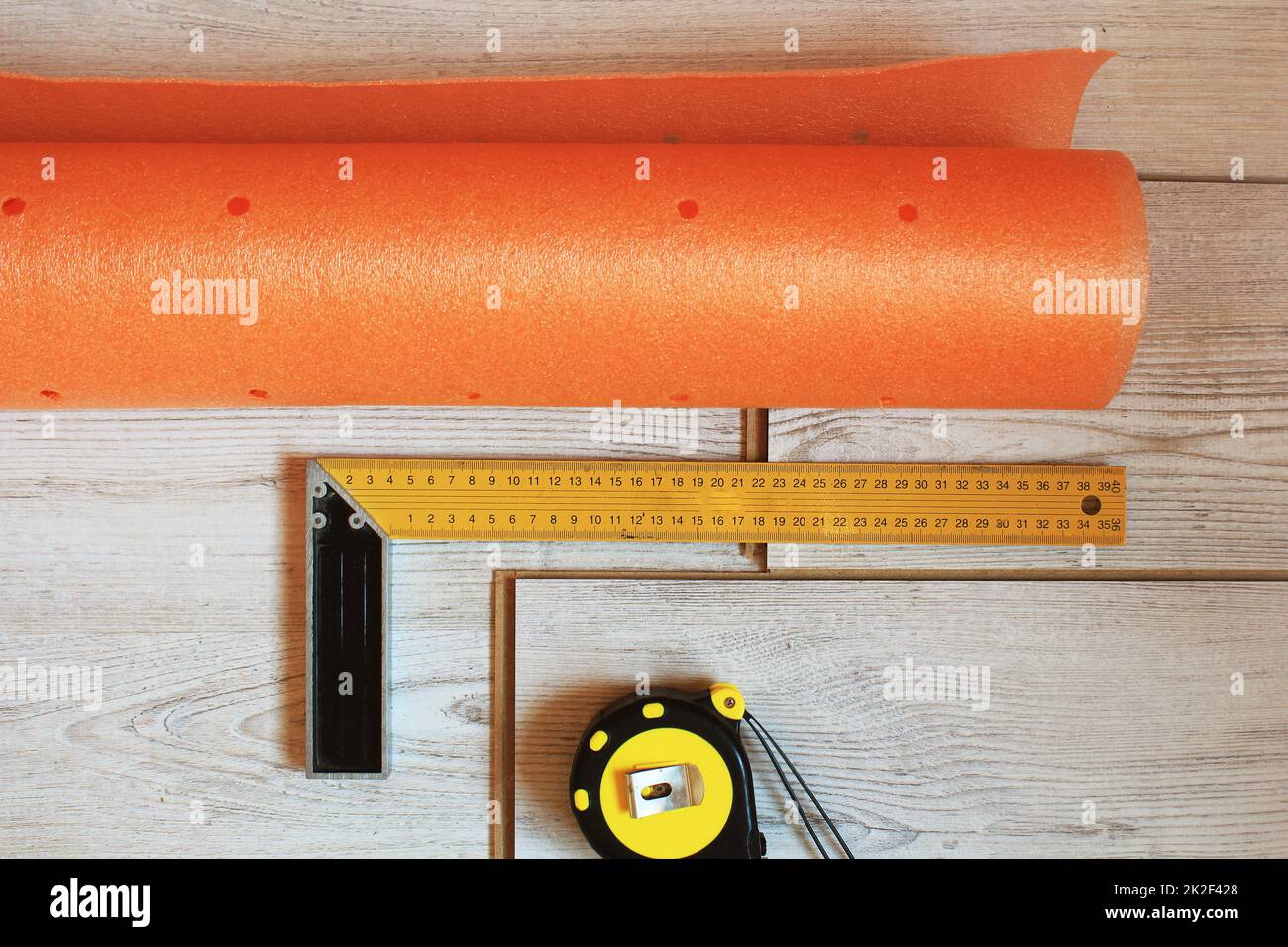 Laminate floor planks and tools on wooden background. Top view. Stock Photo