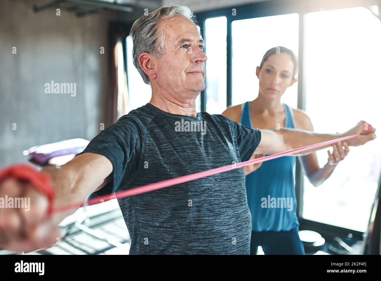 Maintaining healthy muscle no matter the age. Shot of a senior man using resistance bands with the help of a physical therapist. Stock Photo