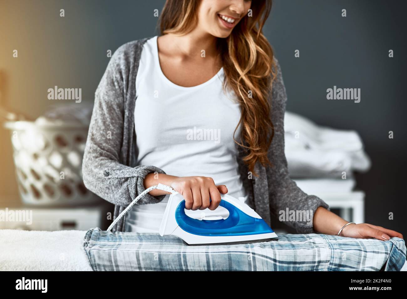 The last step of laundry. Shot of an unrecognizable woman ironing a