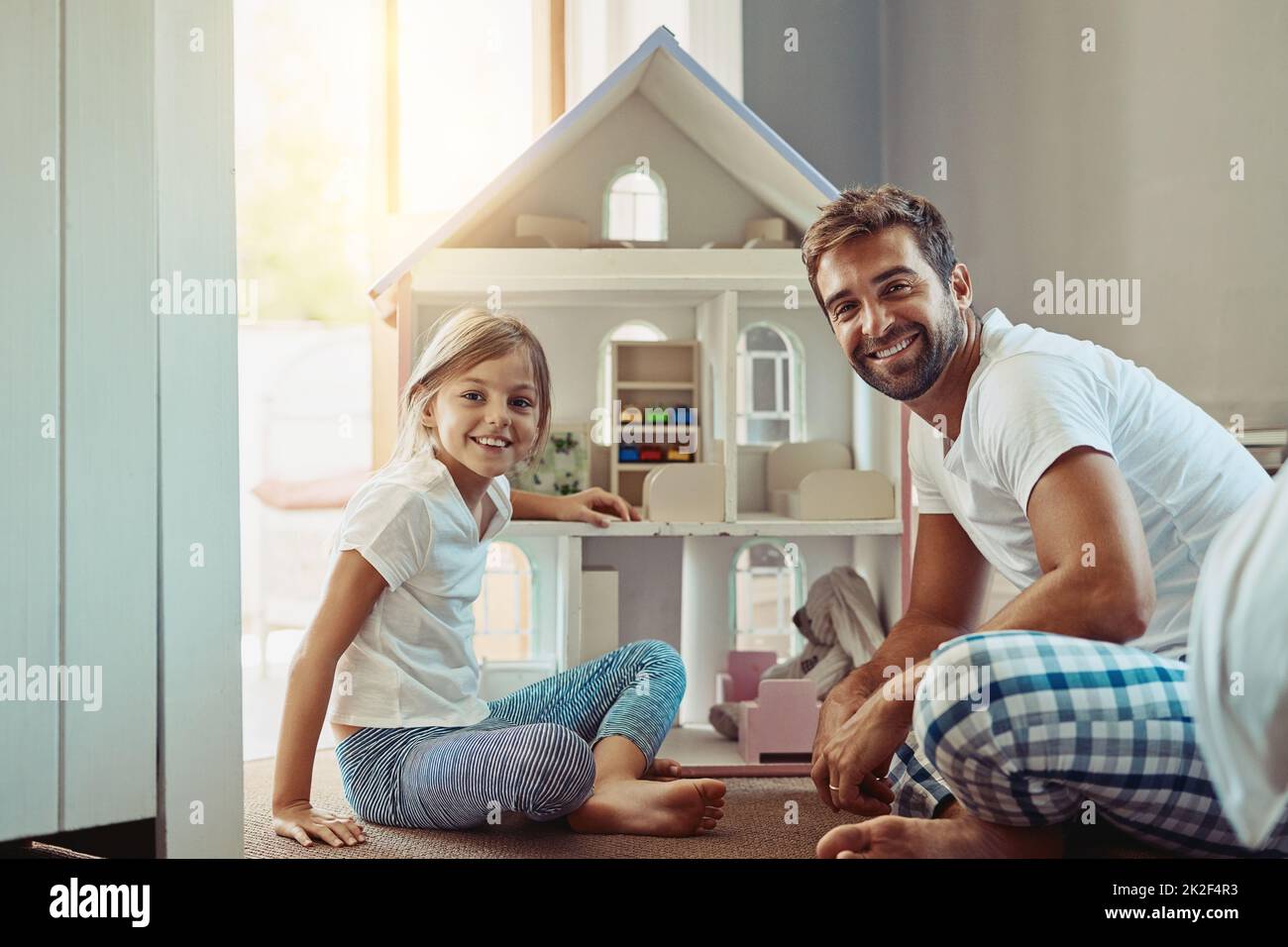 Take any opportunity to bond with them. Shot of an adorable little girl spending time with her father at home. Stock Photo