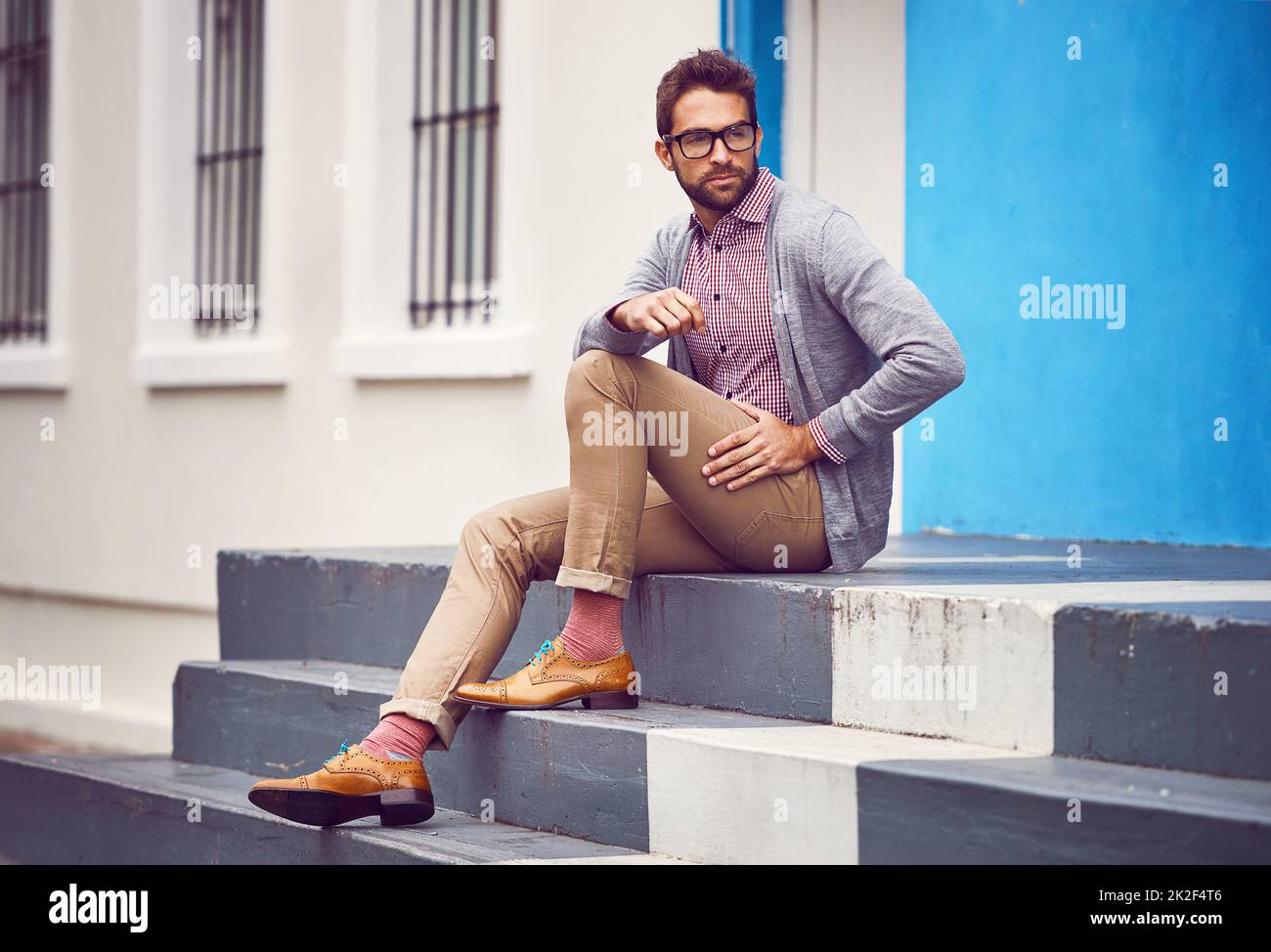 Sometimes the streets of the city are my inspiration. Shot of a handsome young man seated on steps outside in the city while being in deep thought. Stock Photo