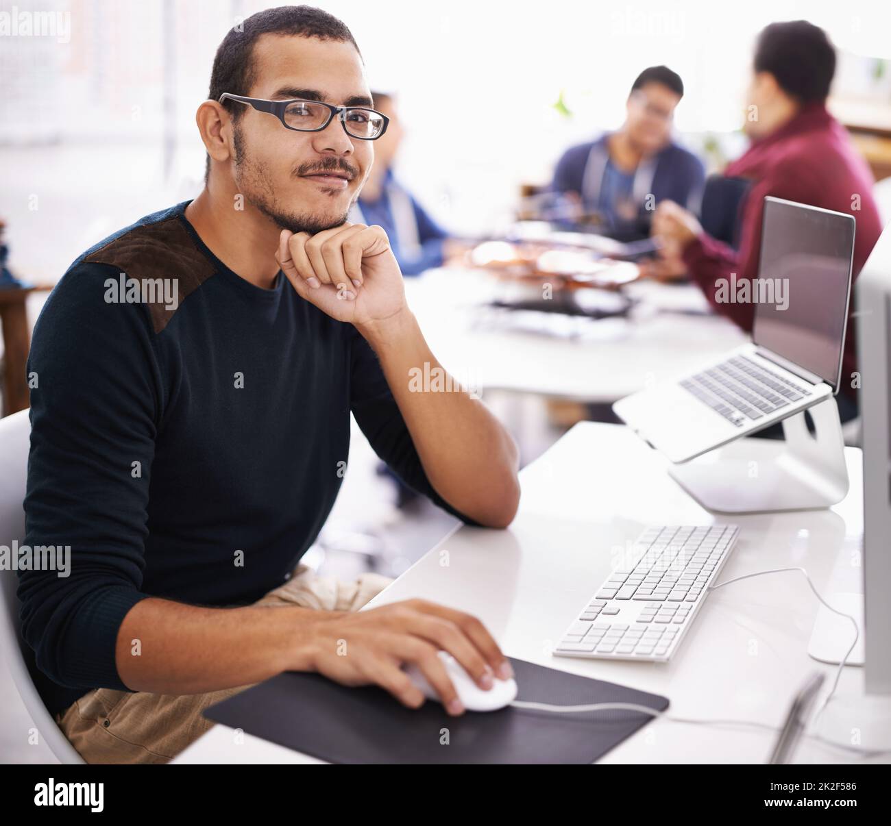 Confident with his role in the team. Cropped shot of a young man working on his laptop in an office. Stock Photo