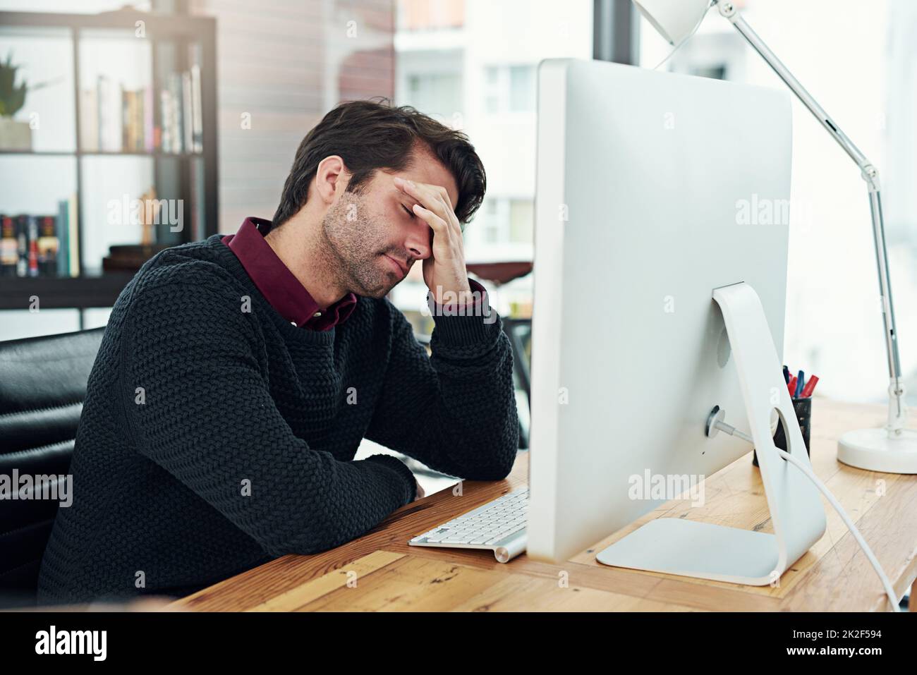 All that work and I forgot to save it. Cropped shot of a young businessman looking dismayed by something on his computer. Stock Photo