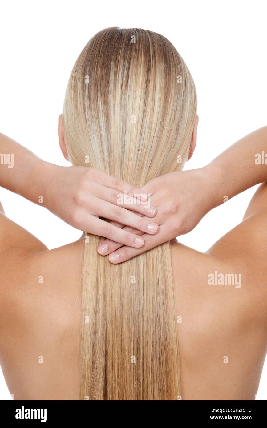 Her hair is her crowning glory. Rear view of a young blonde woman holding her hair against a white backgrouhnd. Stock Photo