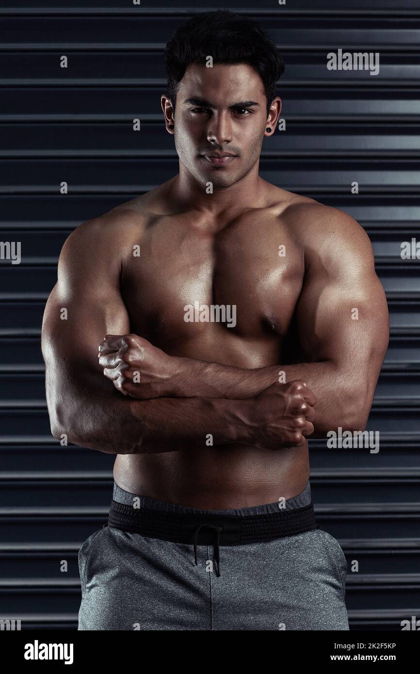 Look at this hunk of a man. Cropped portrait of an athletic young man posing against a dark background. Stock Photo