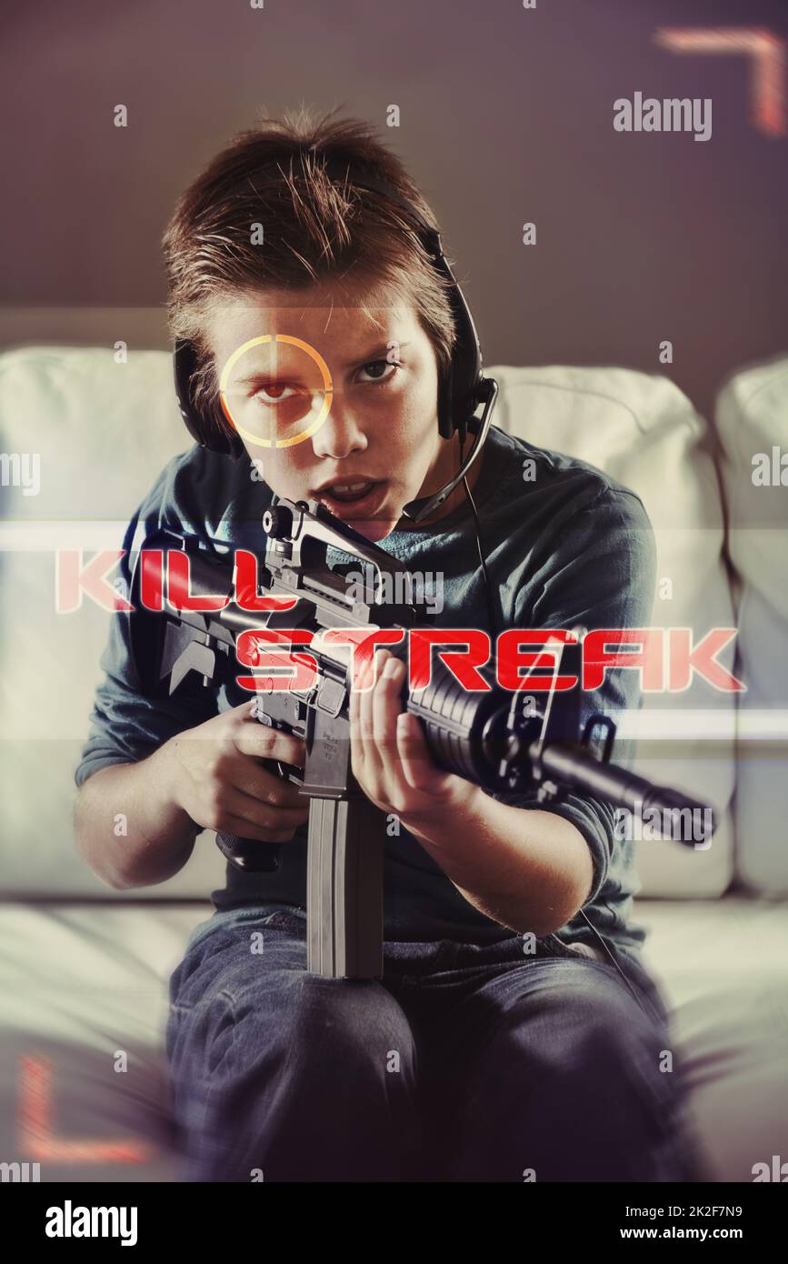 Ive got you. An image of a young boy playing violent video games. Stock Photo
