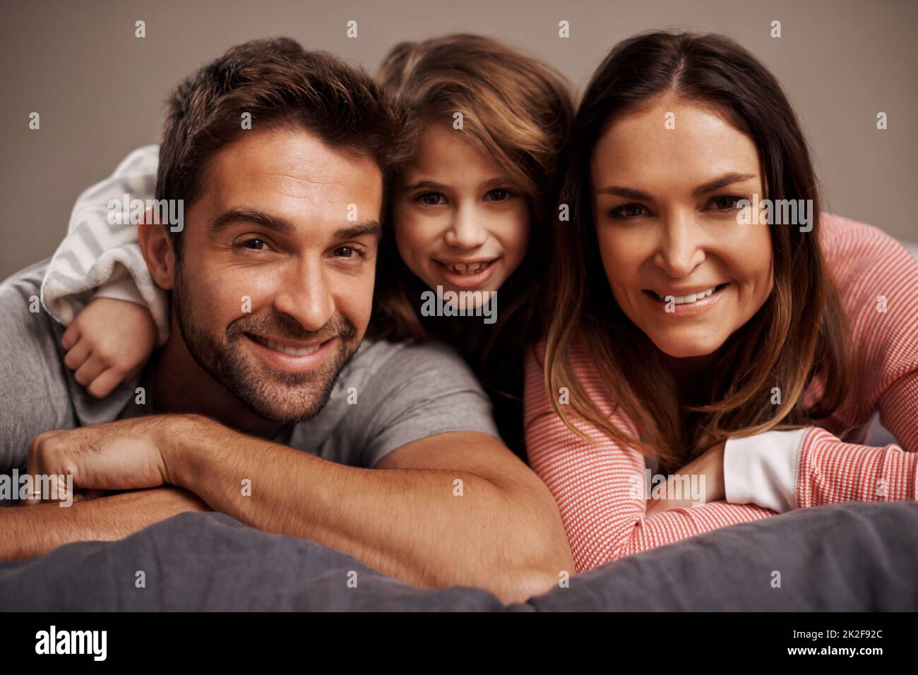 Morning cuddles. Portrait of a happy family lying on a bed Stock Photo