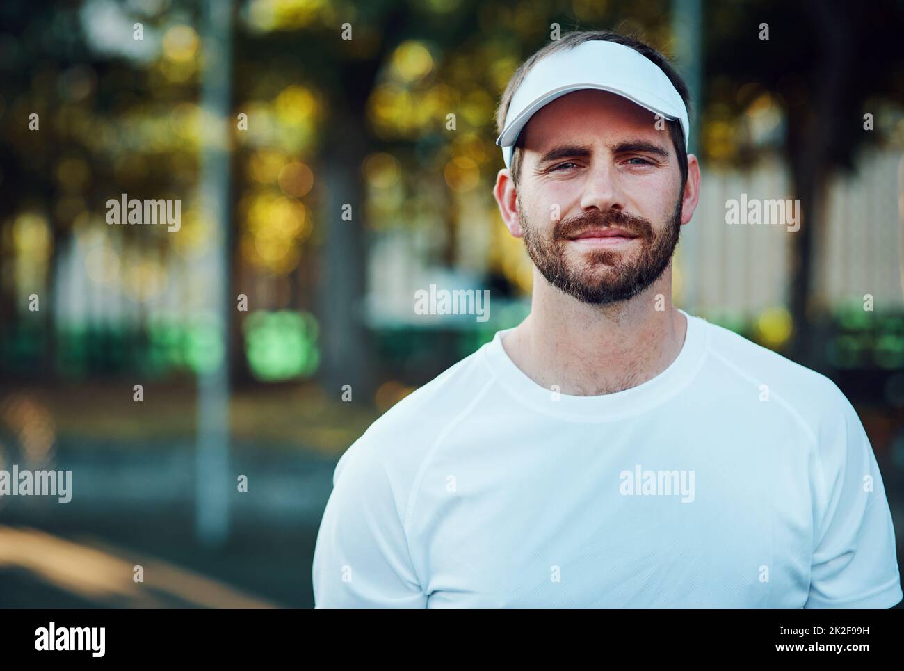 You have to face your challenges head-on. Portrait of a sporty young man standing on a tennis court. Stock Photo