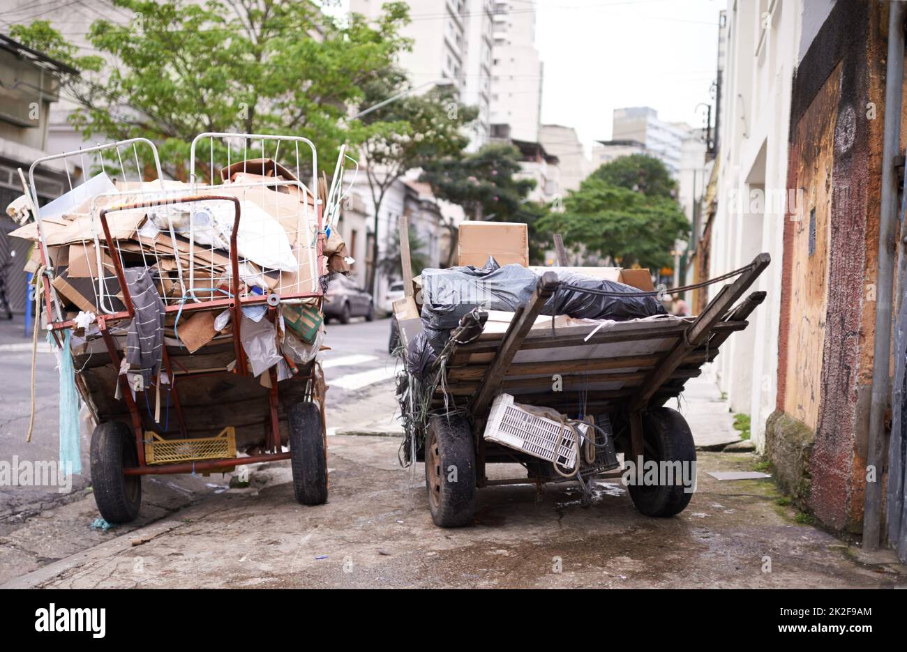 Poverty abounds. Shot of carts full of garbage in the street of a poor neighbourhood. Stock Photo