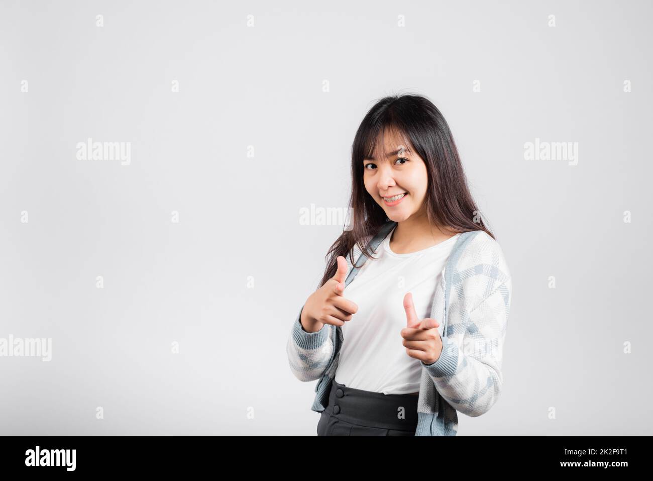 Woman excited smiling makes finger two gun gesture to camera Stock Photo
