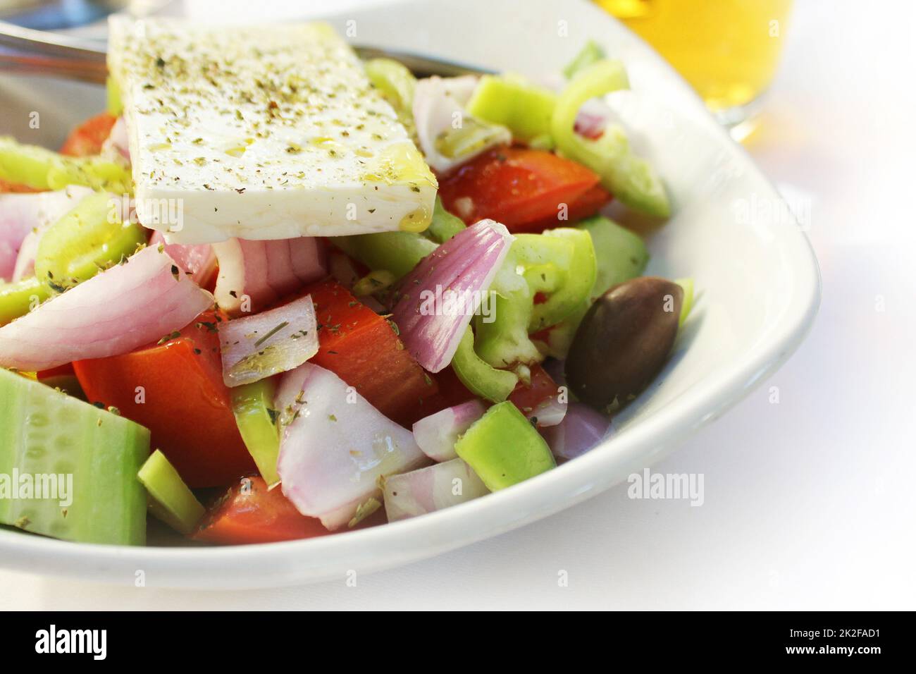 Greek salad with fresh vegetables feta cheese, cucumber,pepper,tomatos and black olives. Vegan food. Healthy food. Stock Photo
