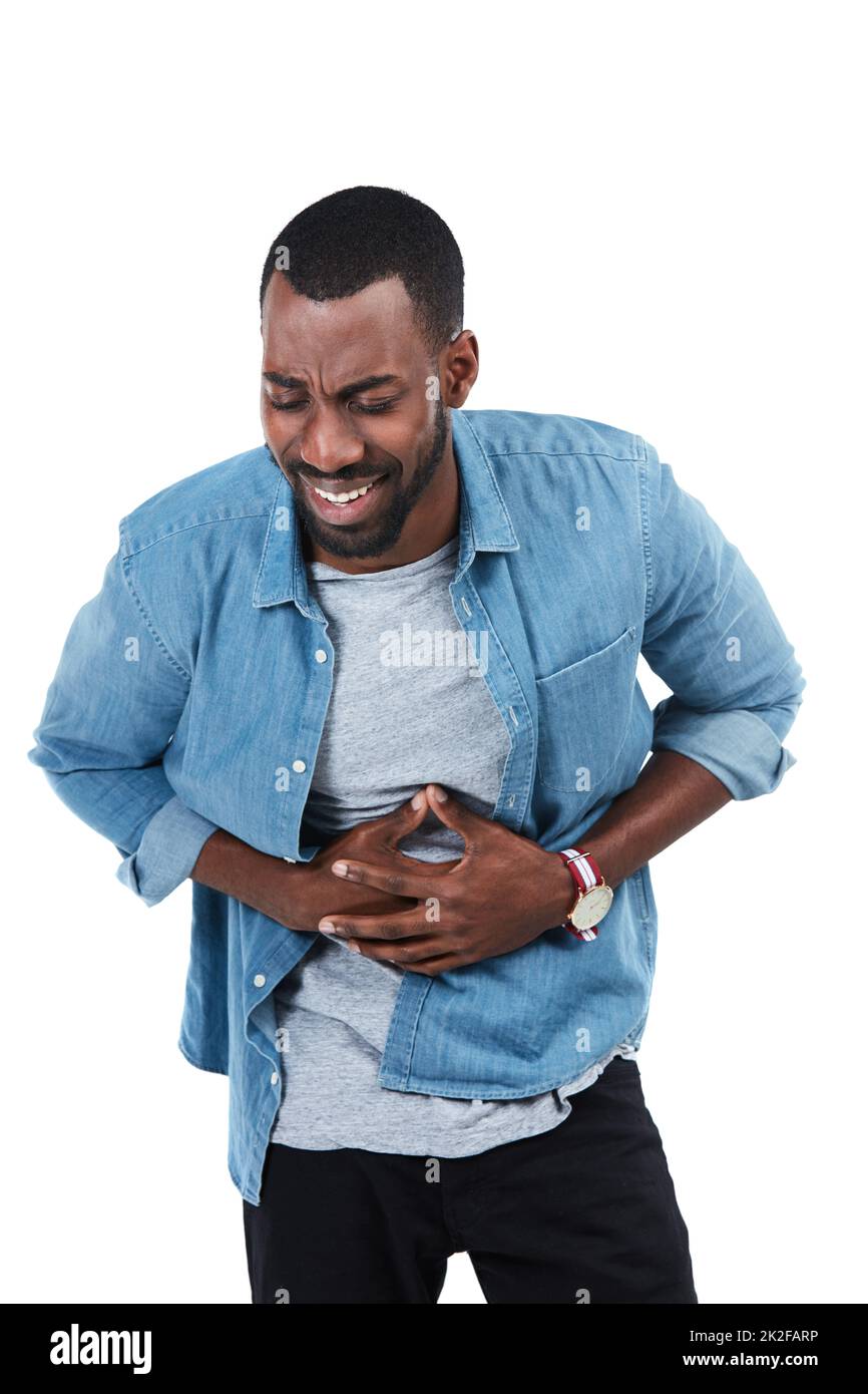 Suffering with stomach cramps. Studio shot of a young man holding his
