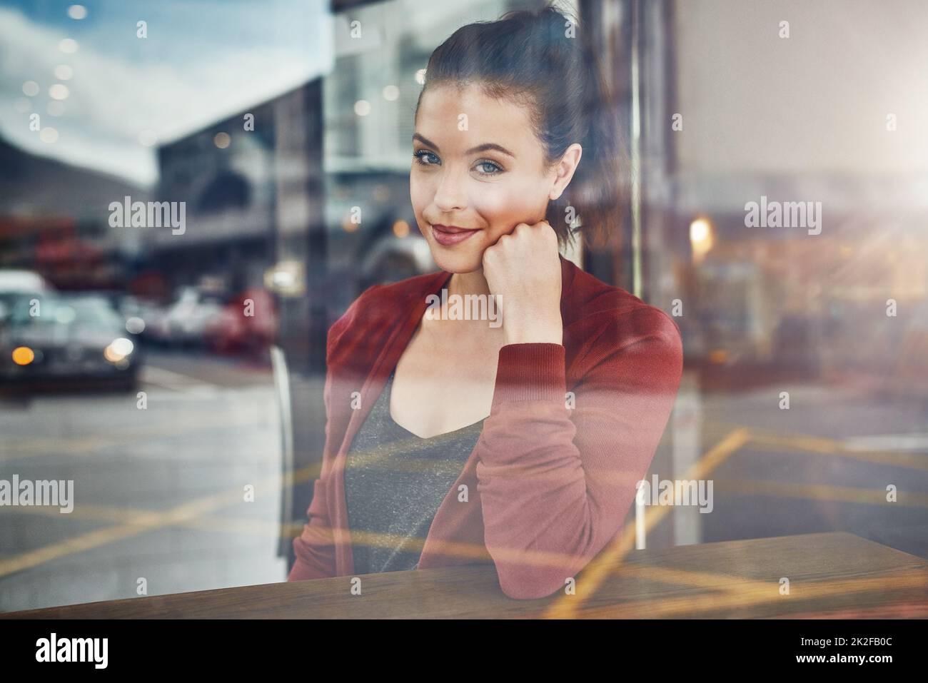 This cafe is a local favorite. Cropped portrait of an attractive young woman sitting in a coffee shop. Stock Photo