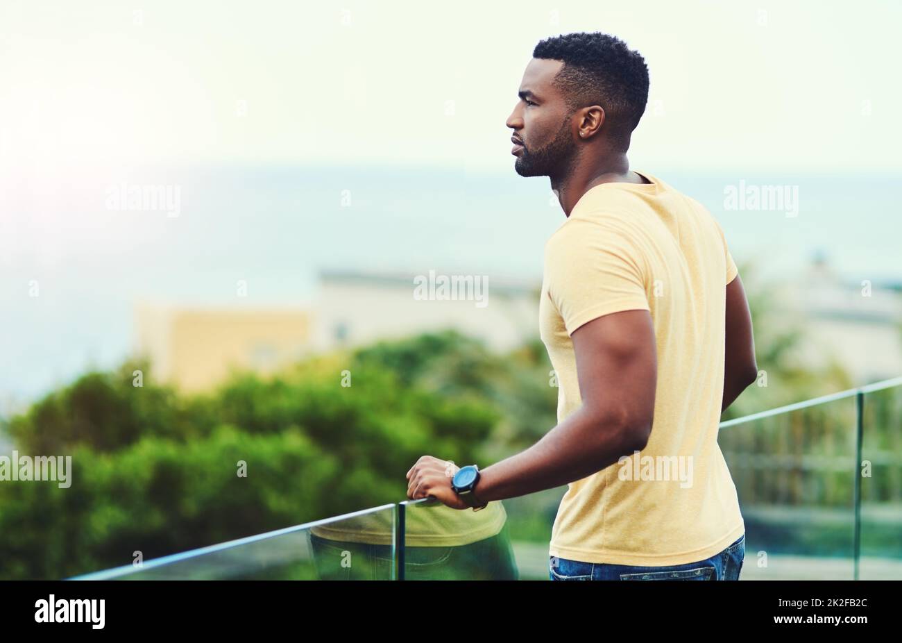 I would have never imagined Id be here one day. Shot of a handsome young man looking at the scenery while relaxing outdoors on holiday. Stock Photo