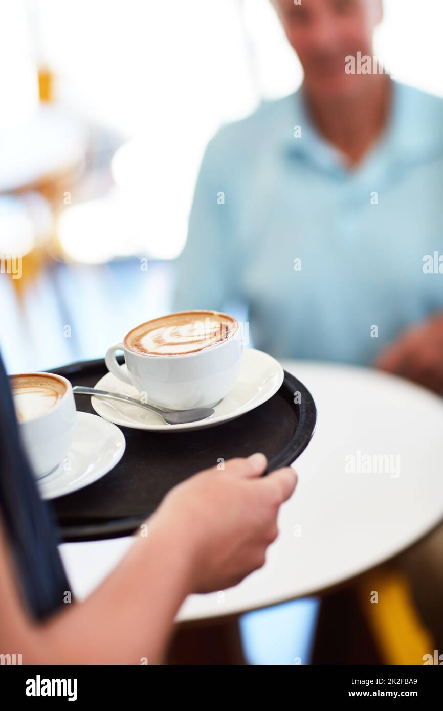 Everything gets better with coffee. Cropped shot of a waitress carrying two coffees. Stock Photo