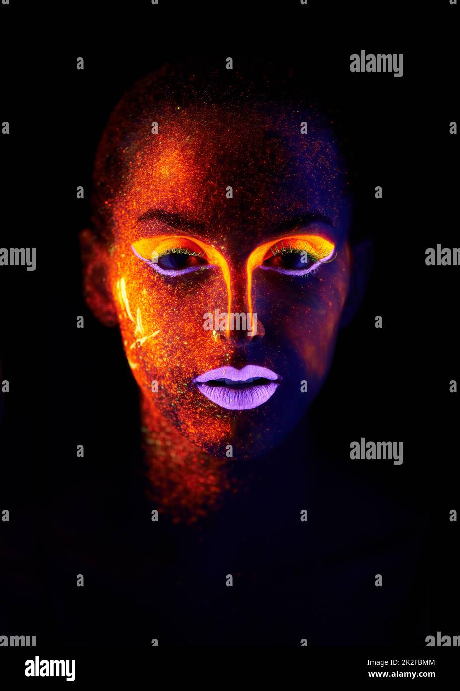 Glowing in the dark. A young woman with with neon paint on her face