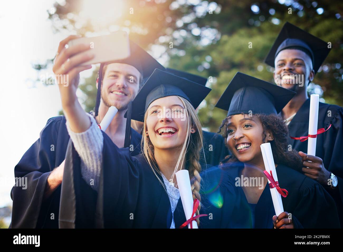 This is a day well never forget. Cropped shot of a group of university students taking a selfie on graduation day. Stock Photo