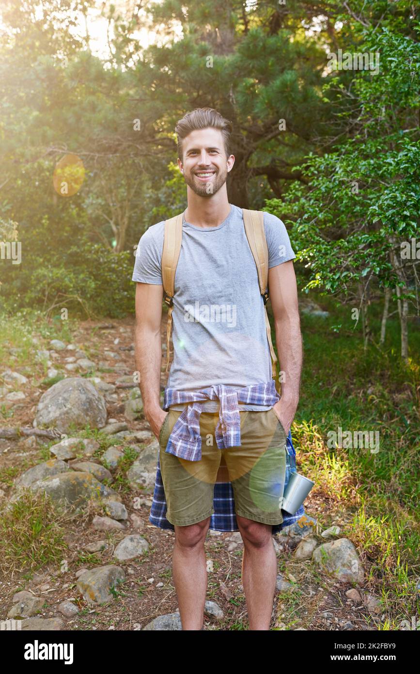 Embrace the beauty of your solo journey. Shot of a happy hiker standing with his hands in his pockets. Stock Photo