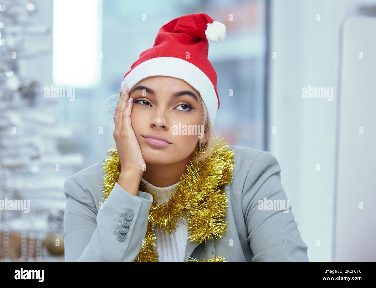 Cant wait to get outta here. Shot of a sad young woman lost in thought at her desk in the office. Stock Photo
