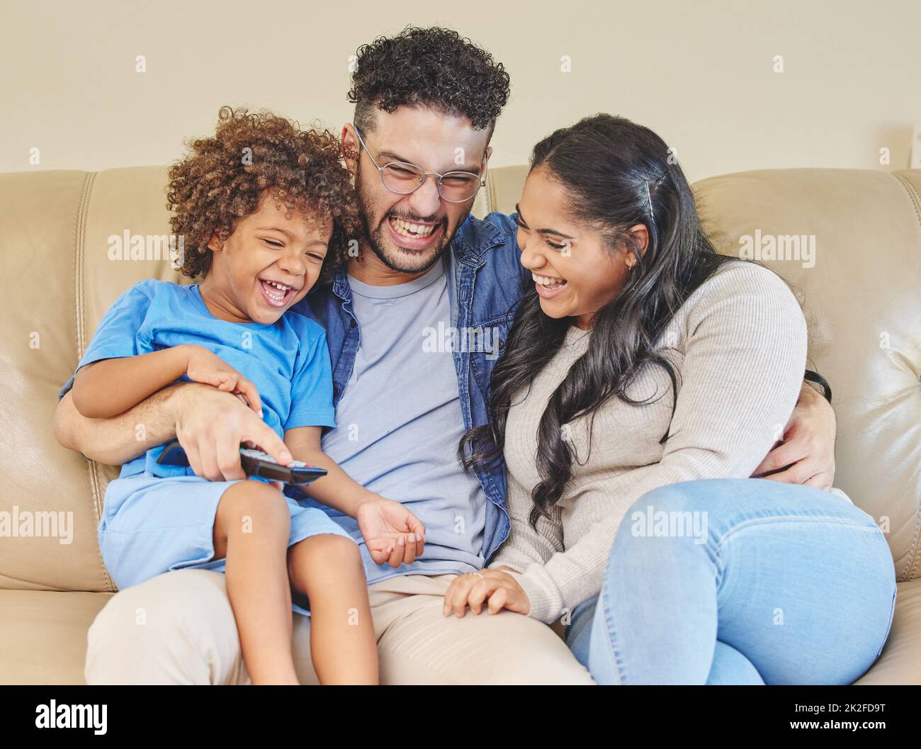 Lets watch our favourite film. Shot of a young family watching TV together. Stock Photo