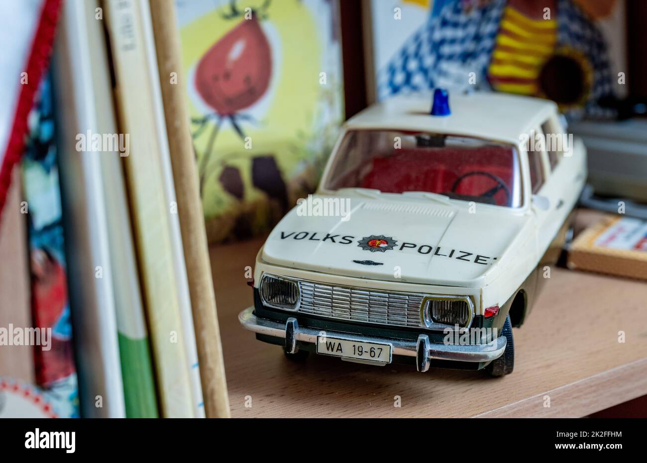 PRODUCTION - 21 September 2022, Saxony, Auerbach: A remote-controlled model Wartburg of the People's Police stands in a GDR children's room in the museum in Auerbach. This weekend, the GDR apartment set up in the Auerbach City Museum will open its door to visitors. A private collector had decided to make his treasures accessible to the public. He had previously collected the items in an 80-square-meter apartment belonging to the Auerbach housing cooperative. The show is based on a new GDR apartment built in the 1980s. On a tour through the living room, bathroom, children's room and kitchen, vi Stock Photo