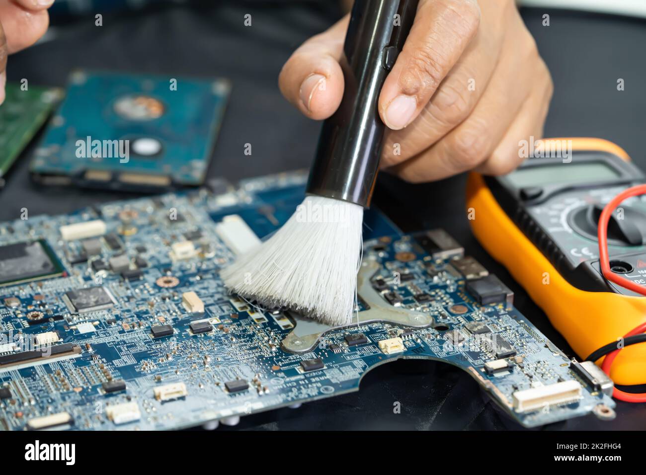 Technician use brush and air blower ball to clean dust in circuit board