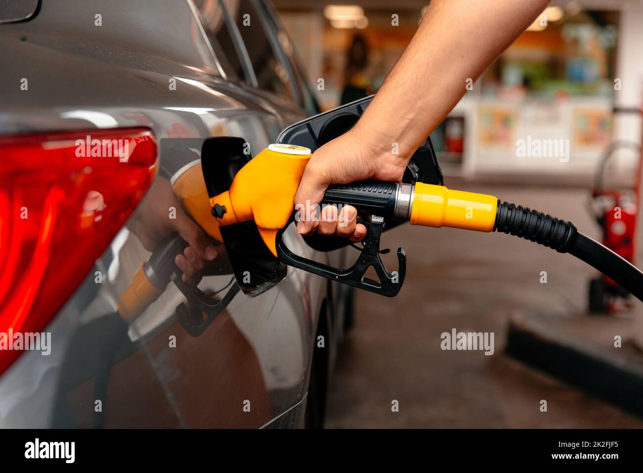 Hand Man Refill and filling Oil Gas Fuel at station. Gun petrol in the tank to fill. Fuel business Stock Photo