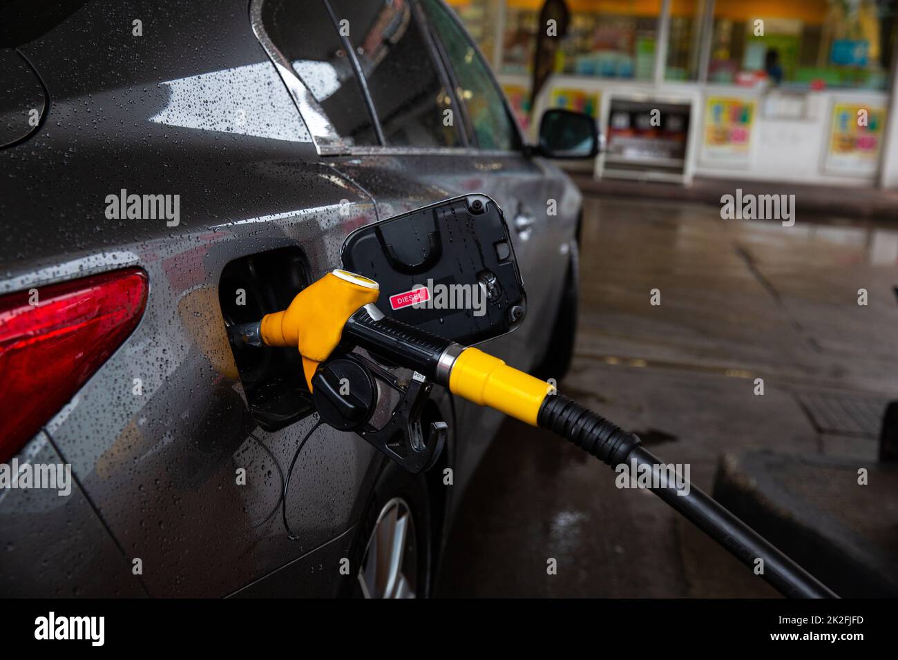 The car is refueling at the gas station. Refueling automobile with