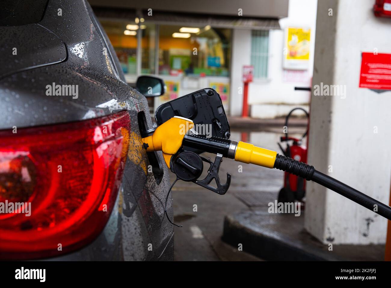 Pumping gasoline fuel in car at gas station. Refueling automobile with