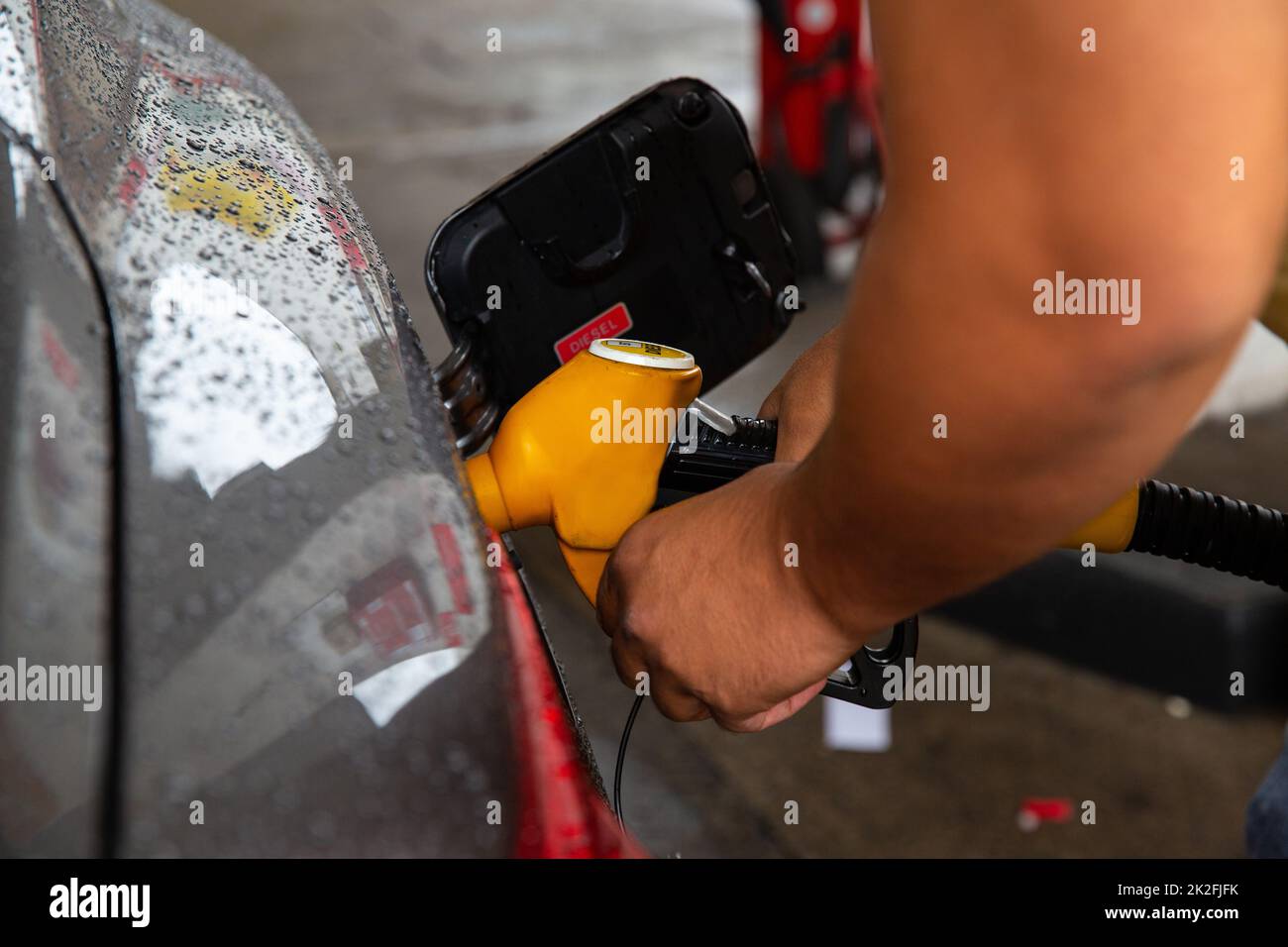 Man filling gasoline fuel in car holding pump. Stock Photo