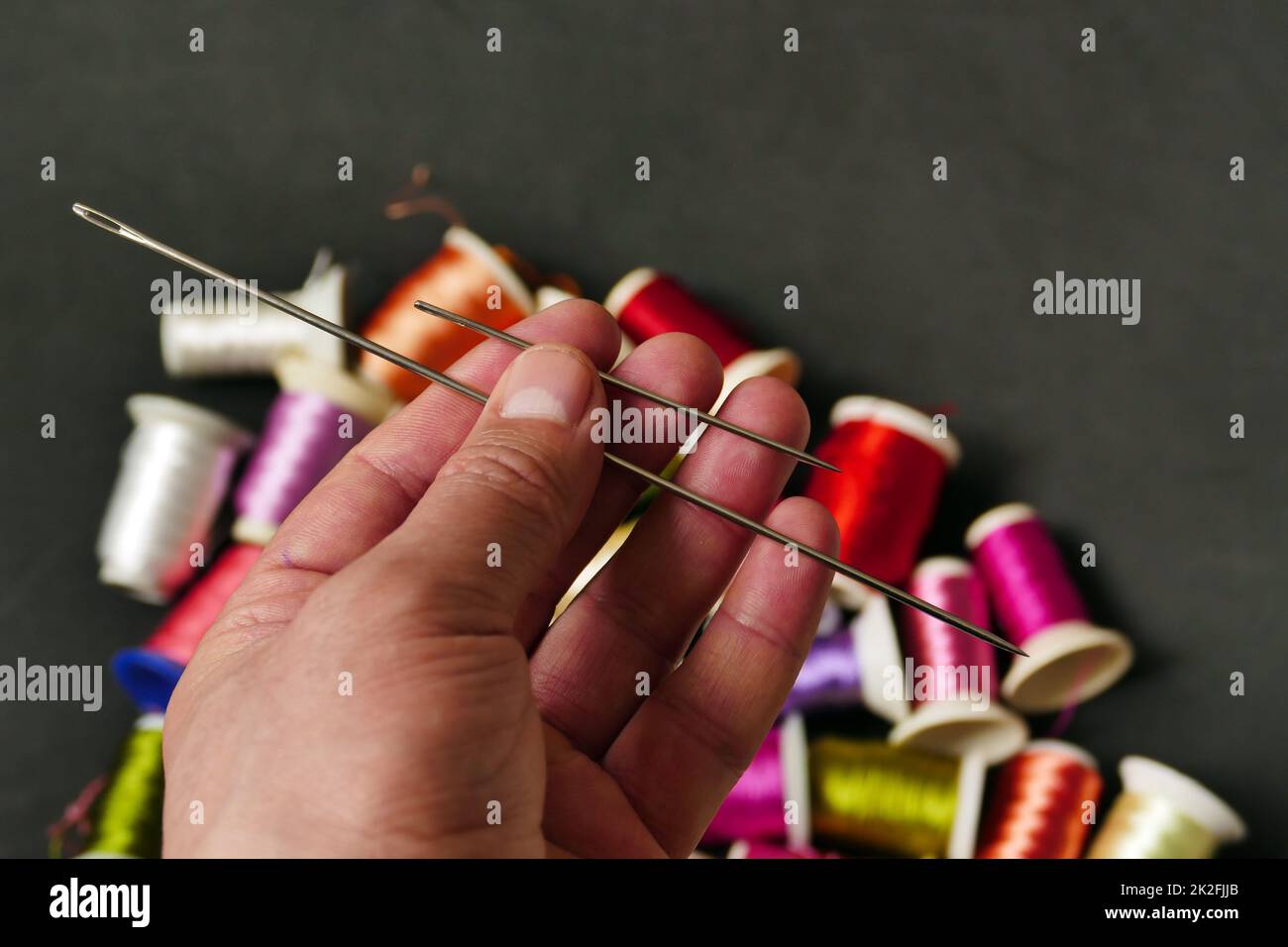 classic sewing needle and threads in a tailor's hand,sewing needle closeup Stock Photo Alamy