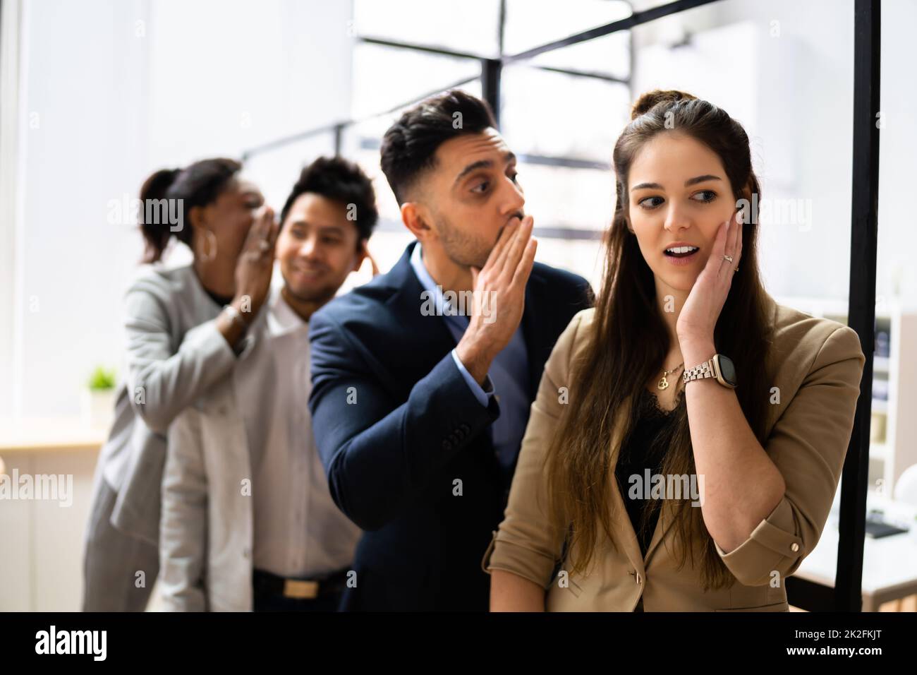 Business Colleague Whispering Secret Gossip To An Man Stock Photo