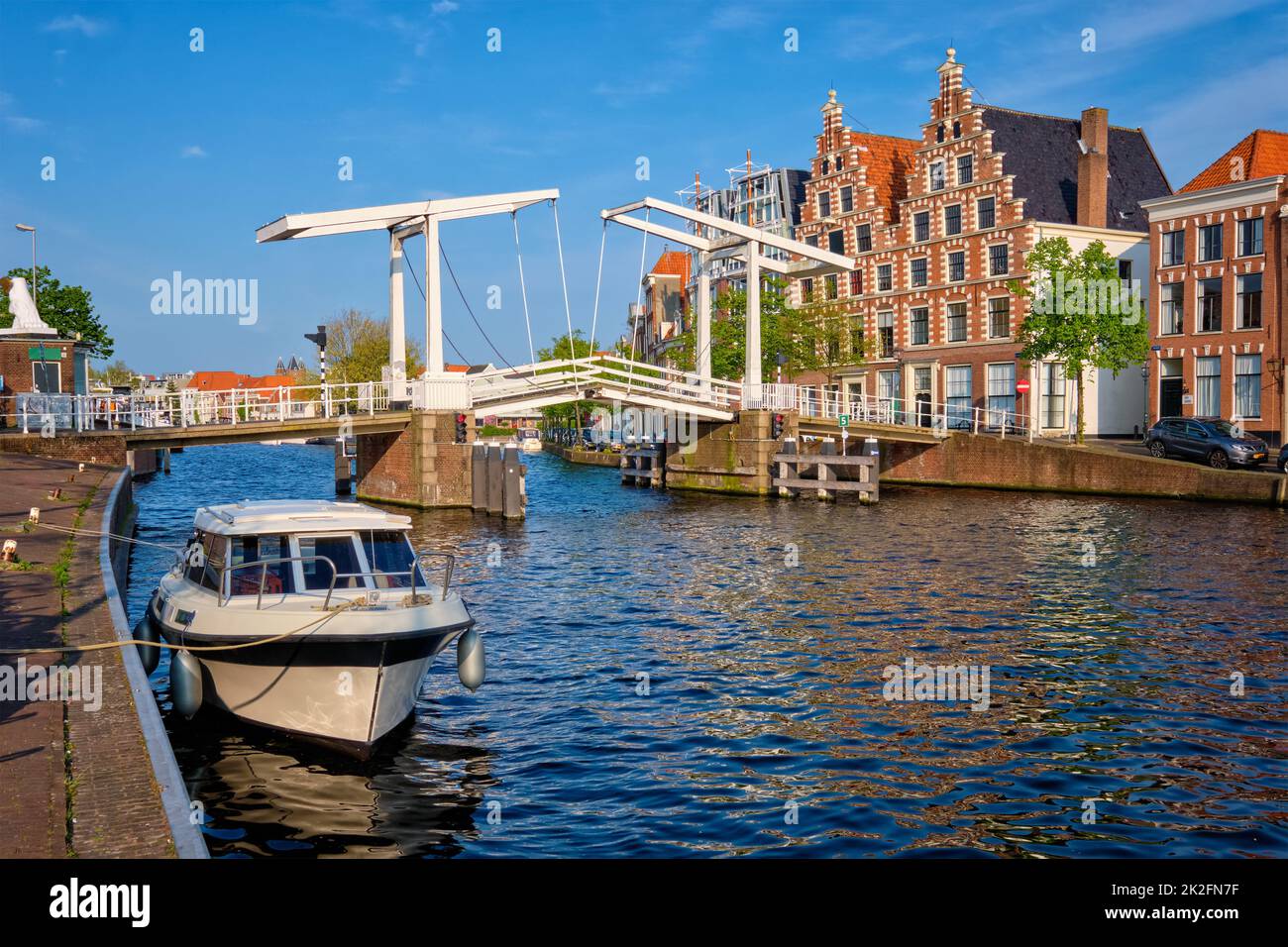 Spaarne river with boat and Gravestenenbrug bridge in Haarlem, Netherlands Stock Photo