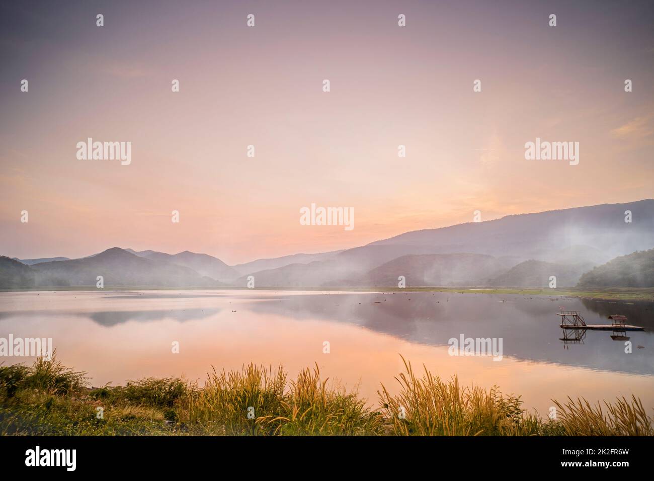 idyllic  Dramatic Sunset with the scene of fog Over The Lake Mountains on background at Khao Luang Reservoir. in Sukhothai Thailand Stock Photo