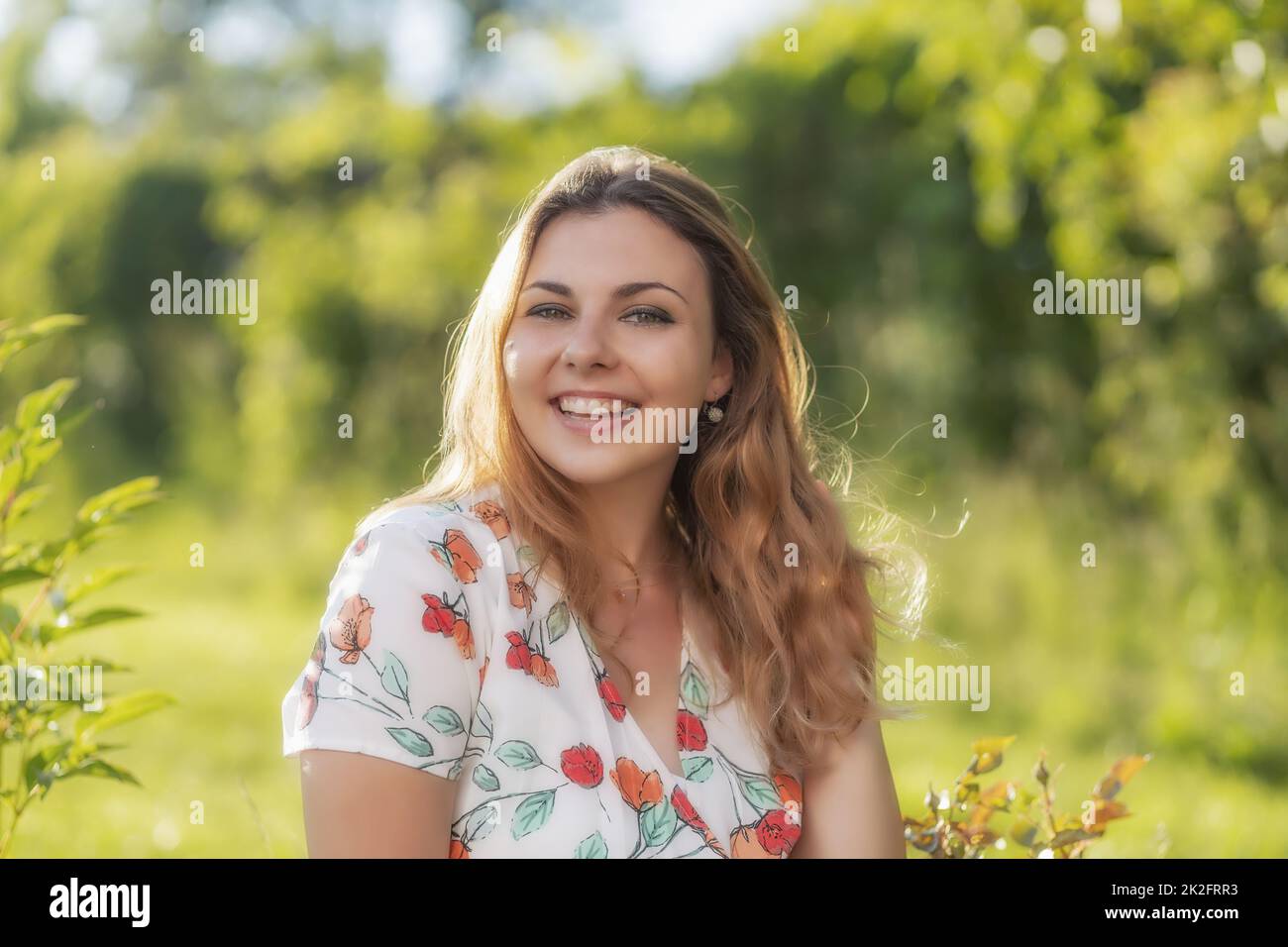 Smiling beautiful young woman is posing outdoors Stock Photo - Alamy