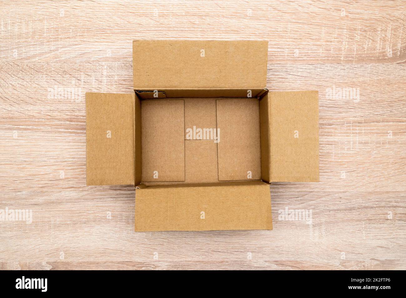 Empty open rectangular cardboard box on the wooden table Stock Photo