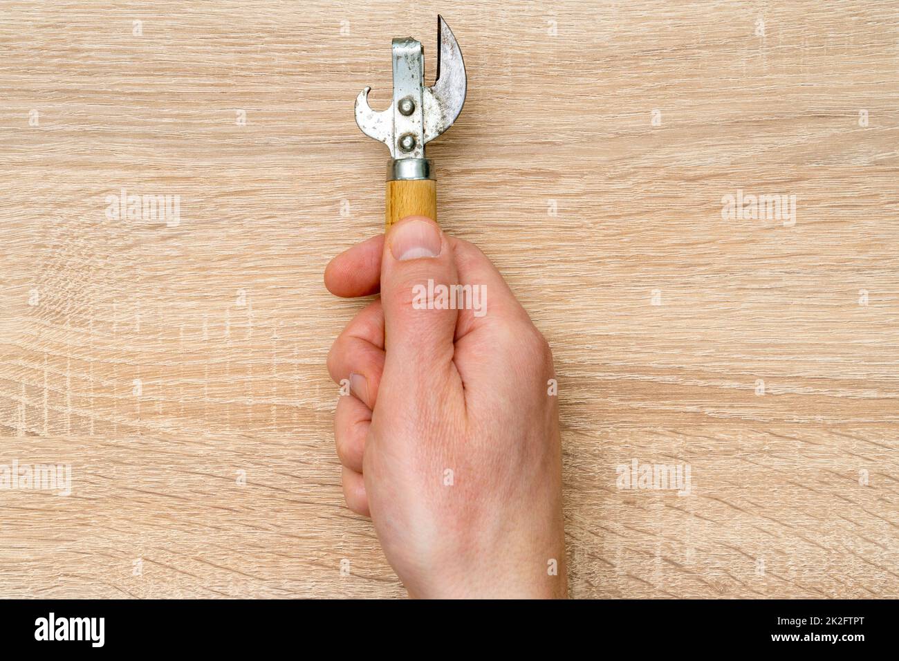 Men hand holds old can opener Stock Photo