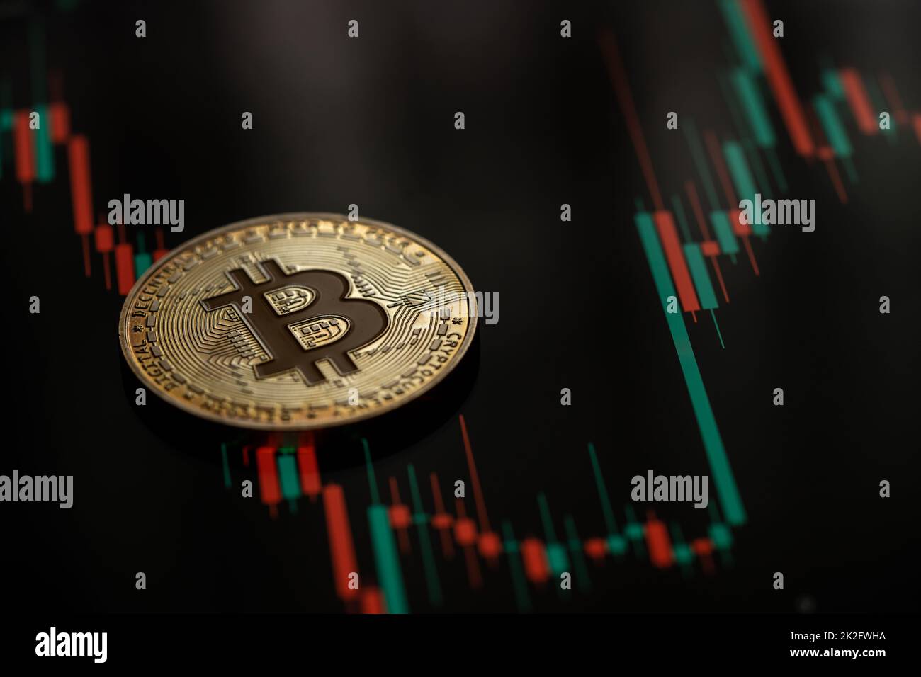 Gold Bitcoin cryptocurrency with candle stick graph chart and digital background. Stock Photo