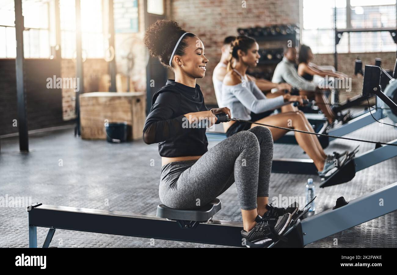 Working out like a pro. Shot of a young woman working out with a rowing machine in the gym. Stock Photo