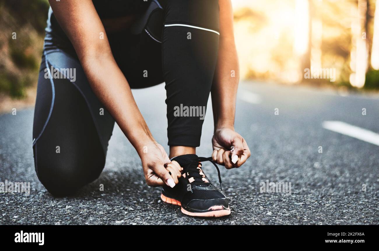 The magic is always in the shoes. Cropped shot of an unrecognizable woman tying her shoelaces. Stock Photo