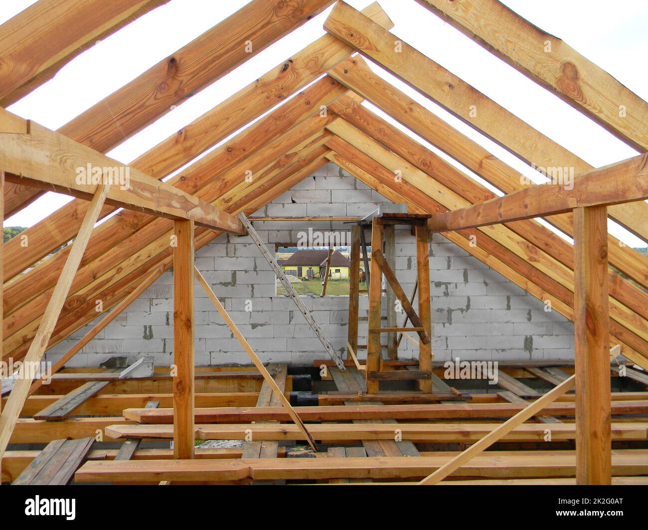 Unfinished attic house roofing construction trusses, wooden beams, eaves, timber.  House roof wooden frame construction. Stock Photo