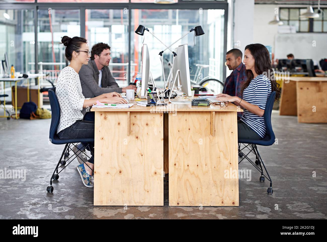 Make creativity a job. Shot of a group of young office workers sitting at their work stations. Stock Photo