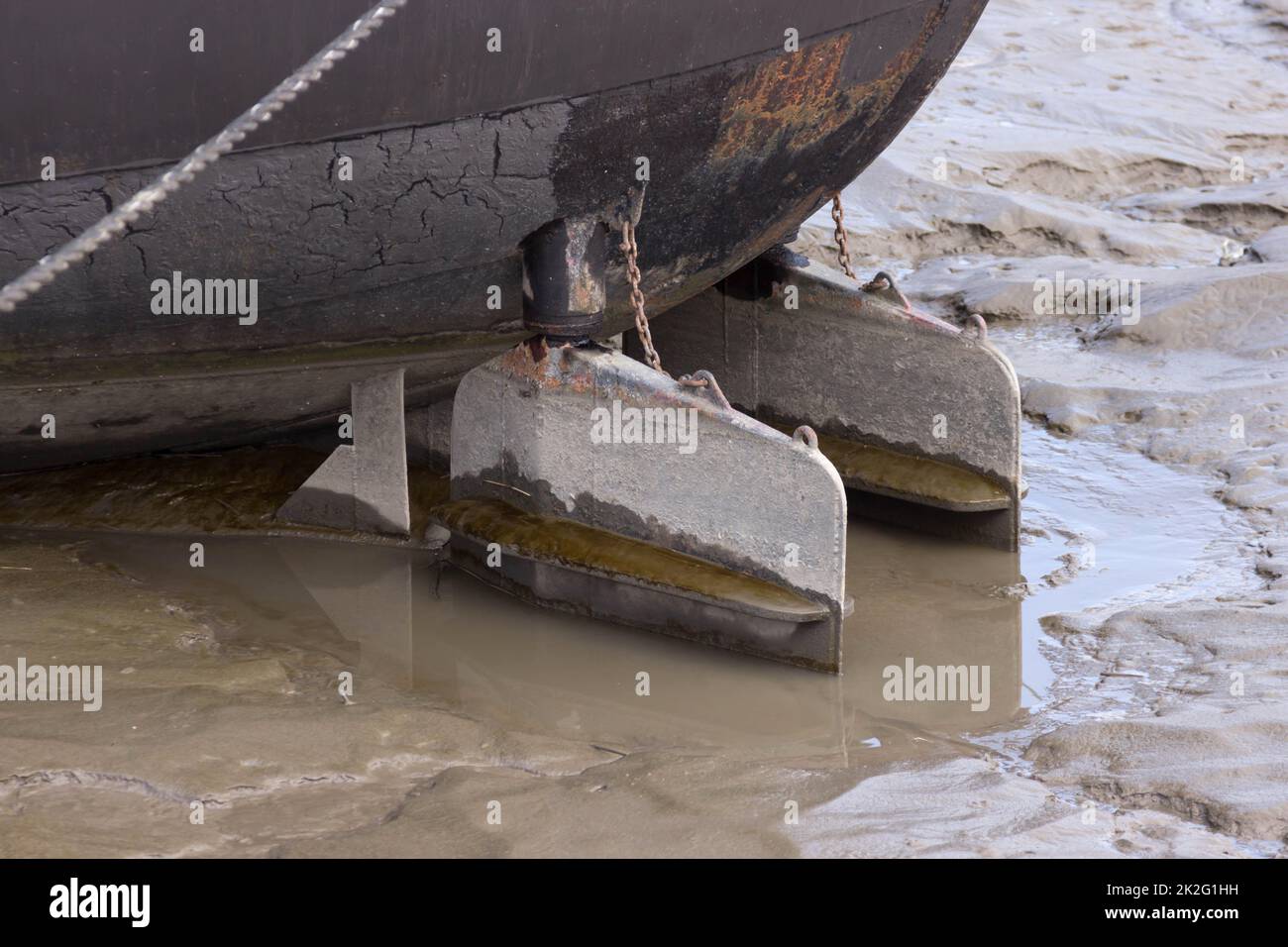 Stern of a ship with rudder in the silt Stock Photo