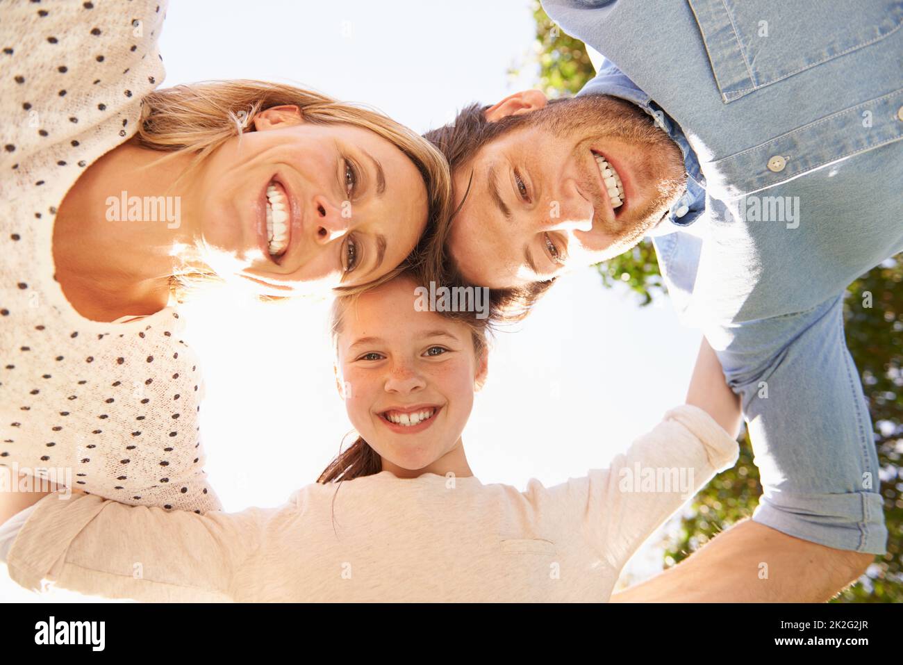 Three heads are better than one. A low angle shot of a happy family in a huddle. Stock Photo