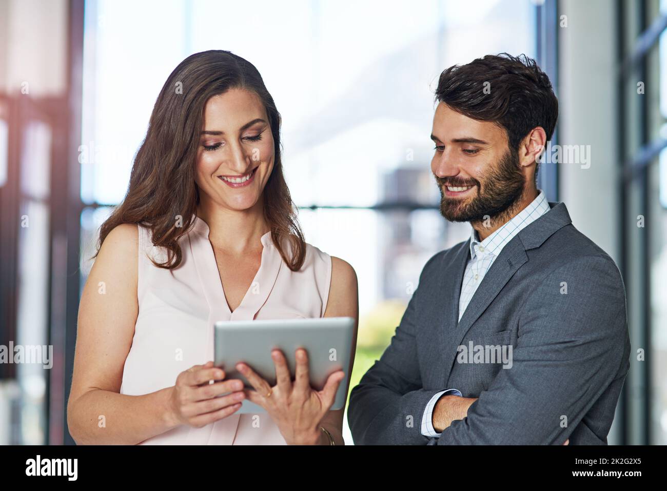 Smart executives use smart technology. Shot of a young businessman and businesswoman using a digital tablet together in an office. Stock Photo